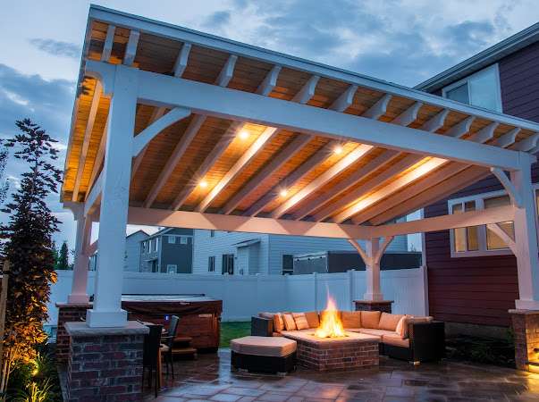 Outdoor patio with fireplace and lighting at dusk.